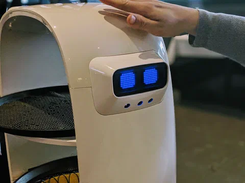 A tray-serving robot with LED eyes in a restaurant